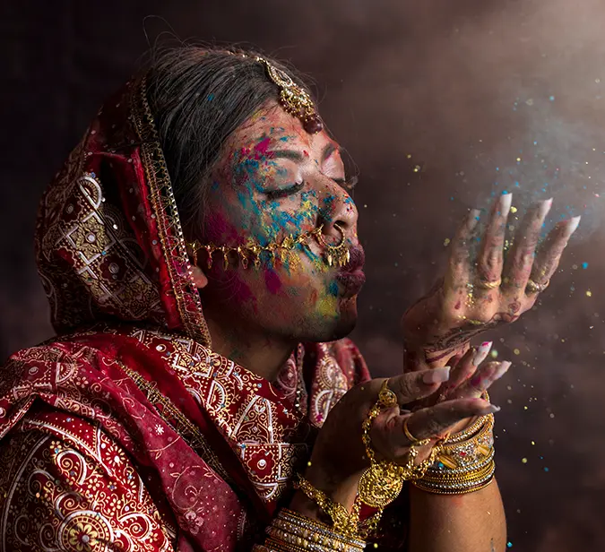 Indian woman playing with colors during Holi festival