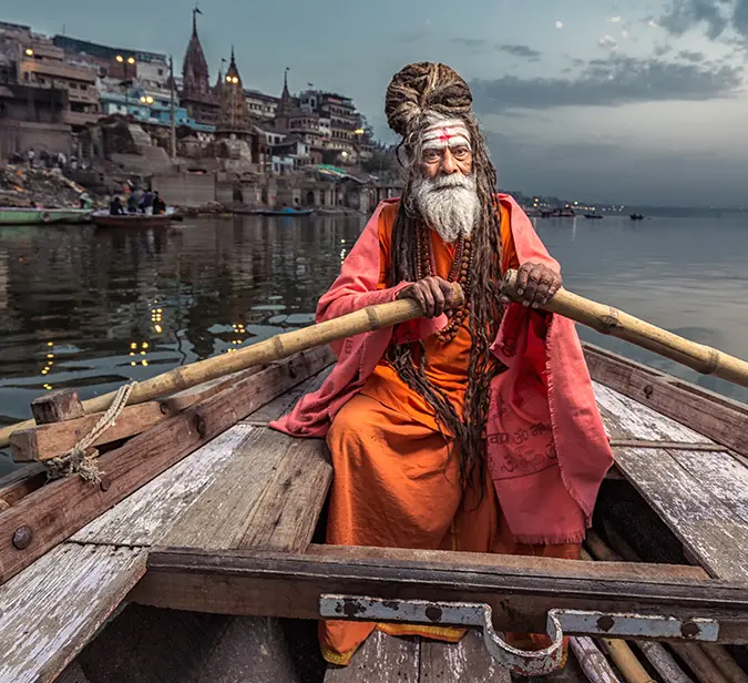 Hindu holy man sitting in a boat on river Ganges in Varanasi